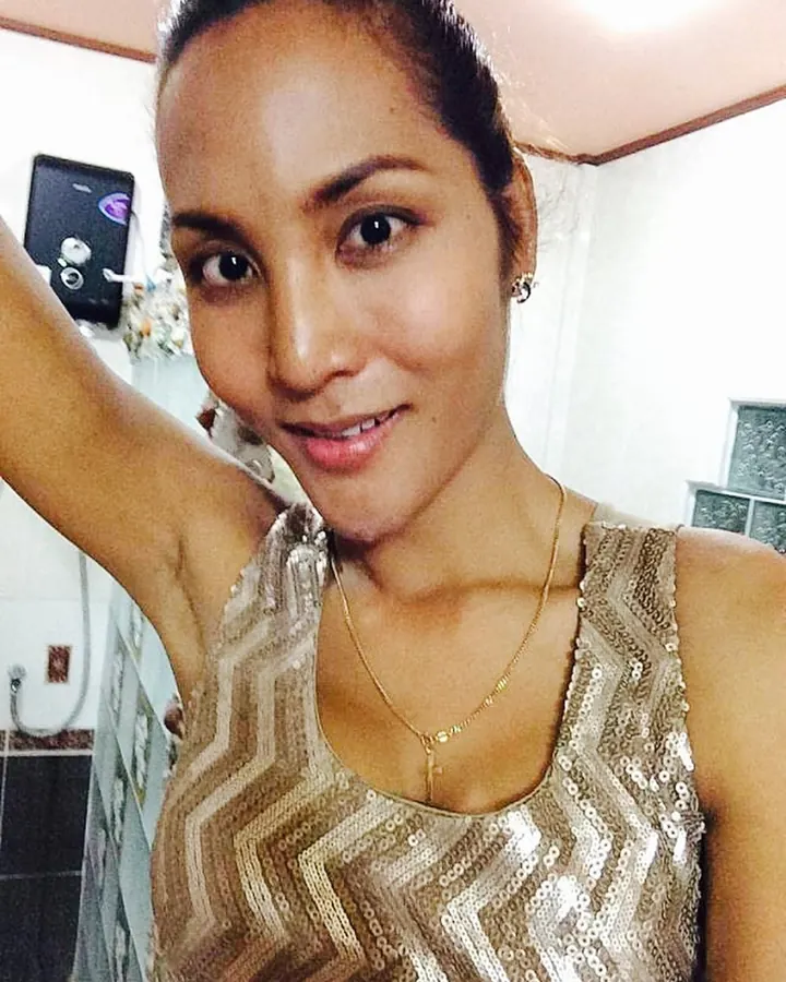 Femme aux cheveux bruns foncés, souriante, prenant un selfie, en haut doré pailleté.