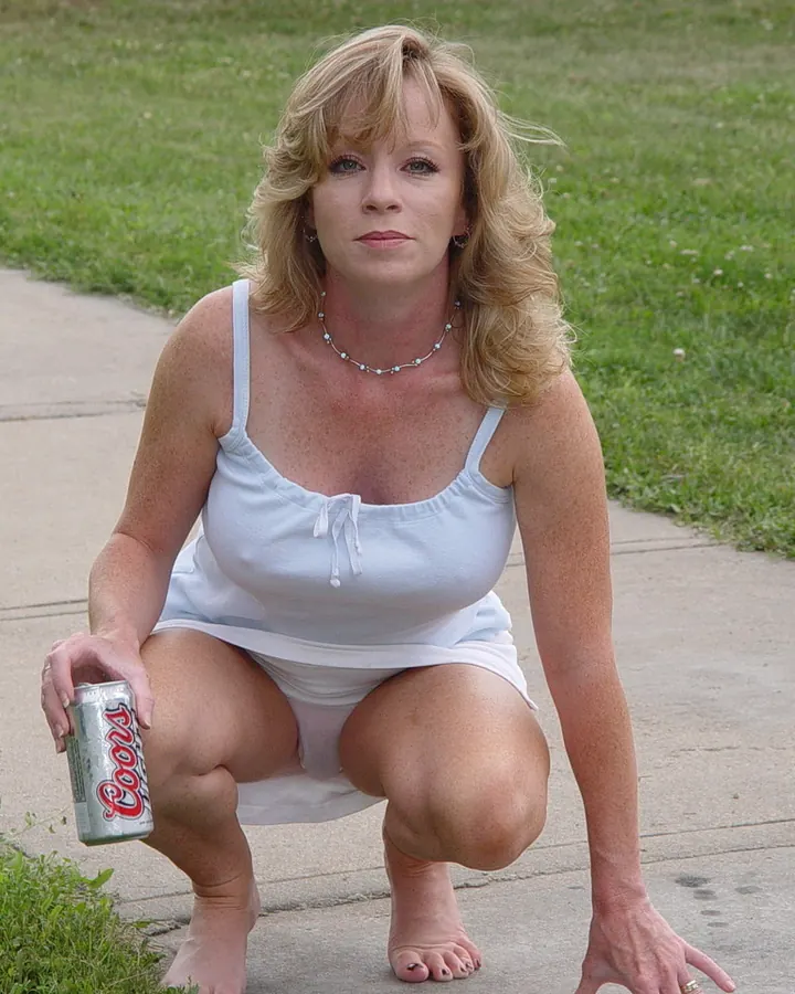 Jeune femme blonde aux yeux bleus, en bikini turquoise, posant devant une porte en bois.