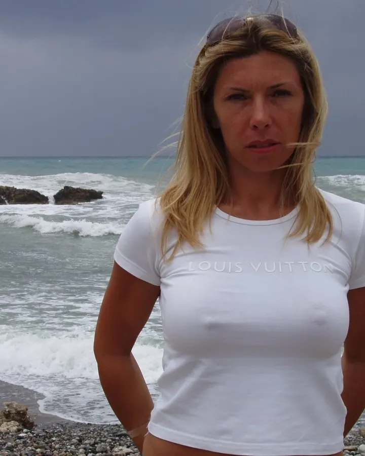 Femme blonde en t-shirt blanc sur fond de mer agitée