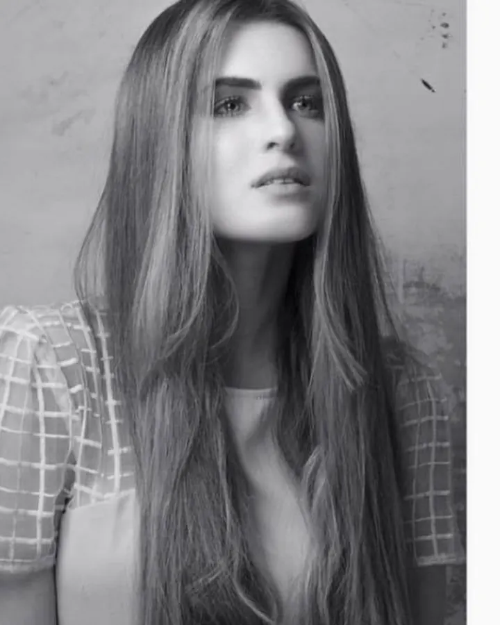 Jeune femme aux longs cheveux, photo en noir et blanc, regardant vers le haut
