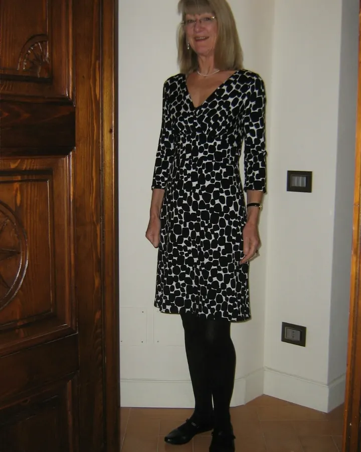 Femme âgée en robe noire et blanche à motifs, collants noirs