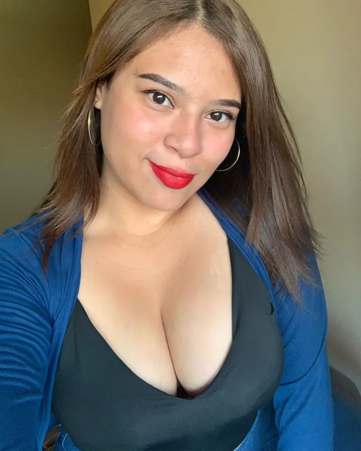 Femme brune en décolleté, rouge à lèvres rouge, selfie